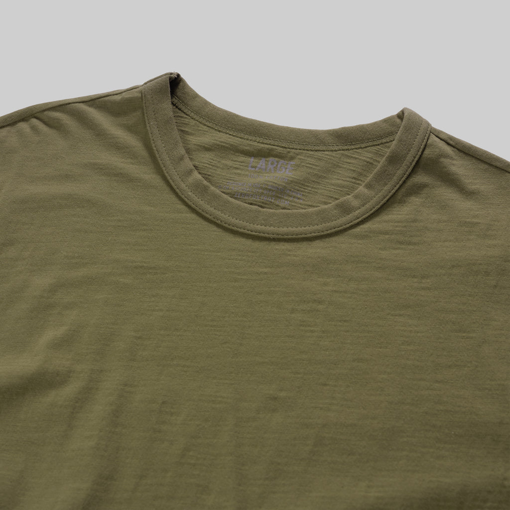 Close-up of an olive green Cotton Skivvy Tee with a crew neckline, showing soft, lightweight fabric and fine stitching details.