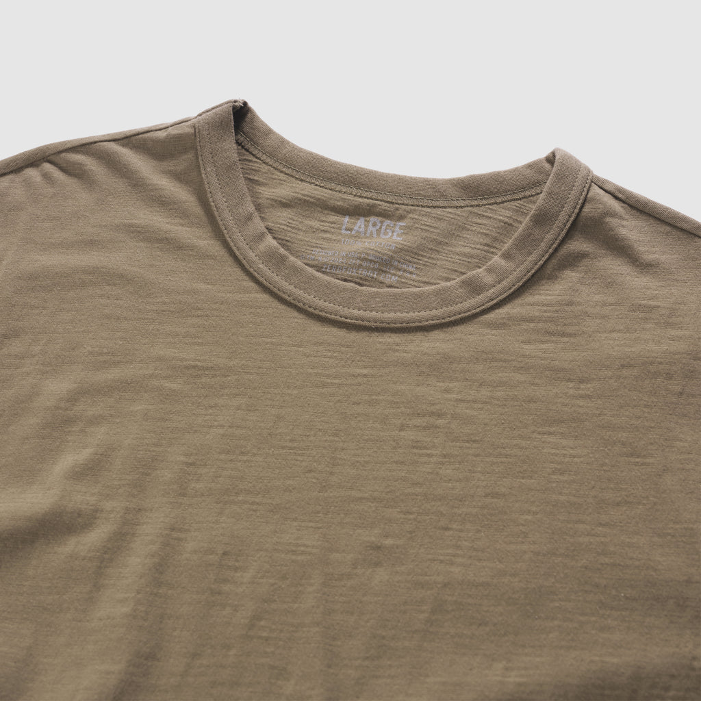 Close-up of a dark brown Cotton Skivvy Tee made from soft cotton fabric, featuring a round neckline and subtle textured detailing.