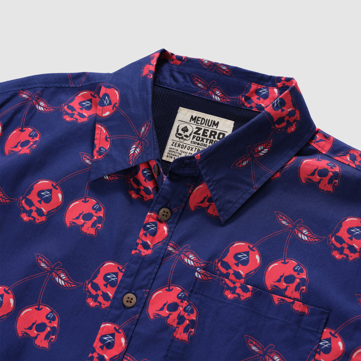 Surf Shirts (Last Chance) navy blue shirt with a button front, collar, chest pocket, and red skull cherry pattern throughout