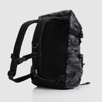 Side view of a Woobie Backpack in black with gray tiger stripe pattern, featuring padded shoulder straps and adjustable buckles for comfortable carrying.