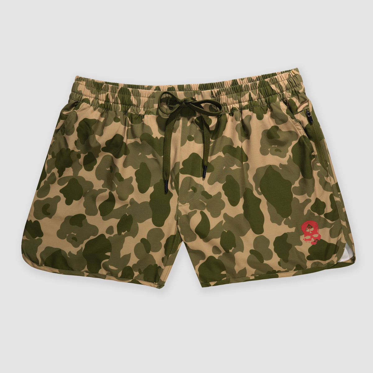 Green and tan camouflage patterned shorts with an elastic waistband and black drawstring, featuring a small red skull logo, Zero Shorts - 5" Inseam.