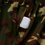 Close-up of a camo-patterned pocket with a zipper partially open, holding a white wireless earbud case, highlighting functionality of the Zero Shorts - 9" Inseam.