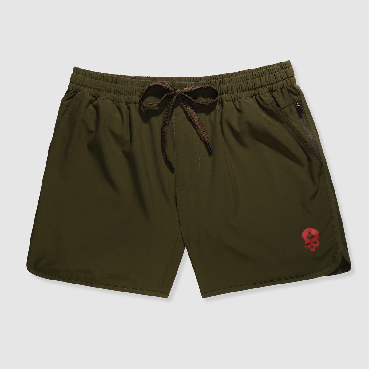 Olive green athletic shorts with an elastic waistband and drawstring, featuring a small red skull logo near the hem and zippered side pockets, Zero Shorts - 7" Inseam.