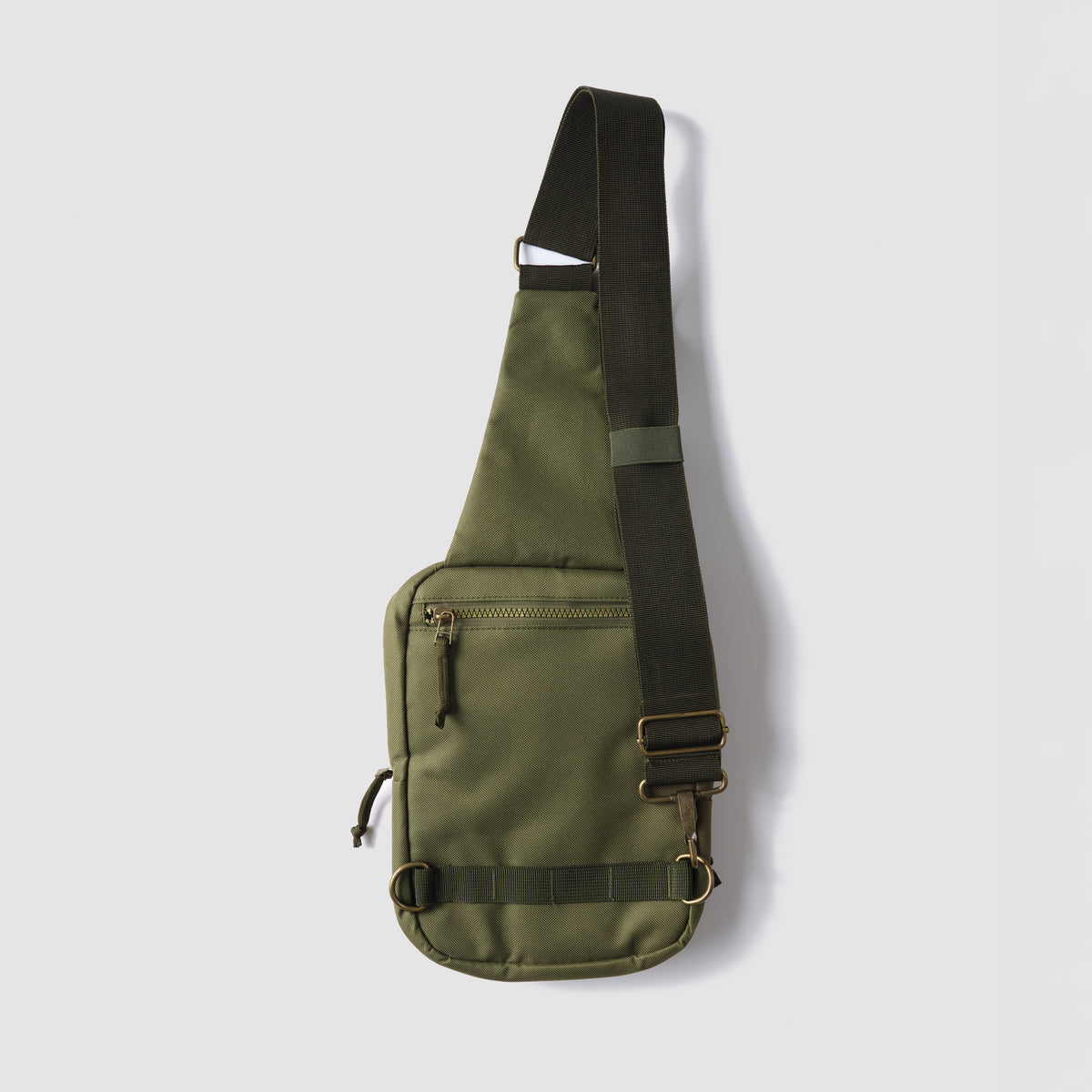 Surplus EDC Sling in olive green with adjustable black shoulder strap, front zip pocket, and metal hardware against a light background