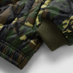 Woobie Zip Hoodie close up showing quilted camouflage fabric, black zipper detail, and ribbed olive green sleeve cuff